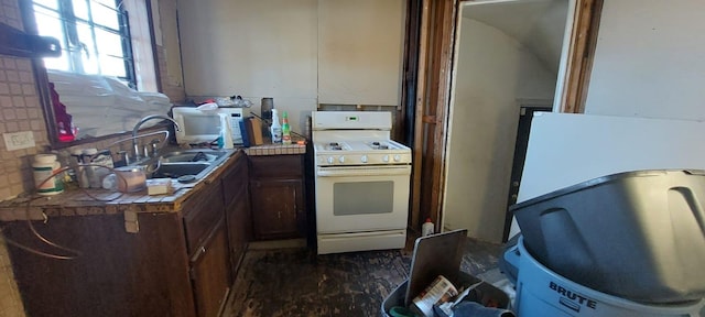 kitchen featuring backsplash, tile counters, sink, and white appliances