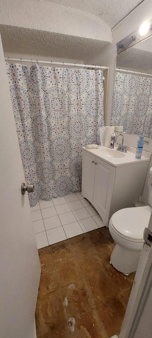 bathroom with vanity, tile patterned floors, a textured ceiling, and toilet