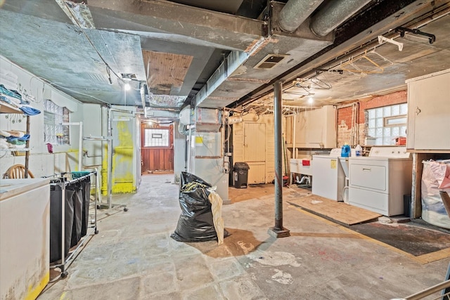 basement featuring heating unit and independent washer and dryer