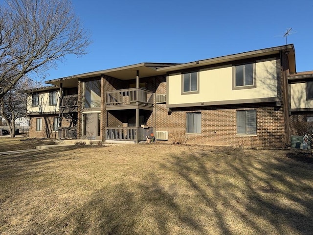 back of property with a balcony, central AC unit, and brick siding