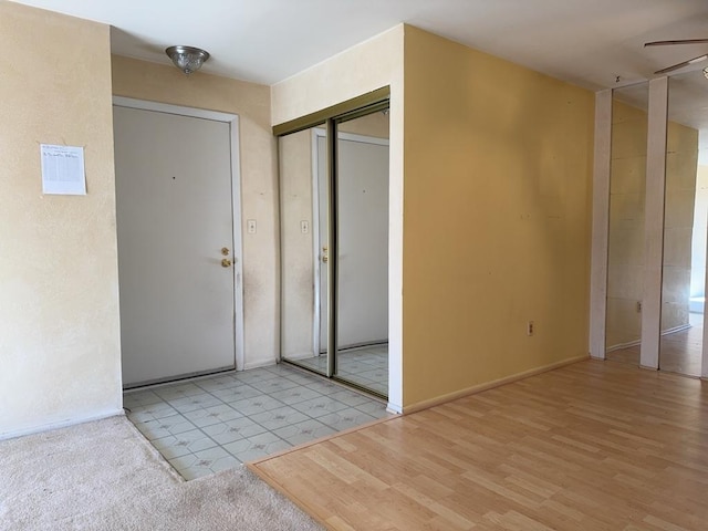 foyer featuring baseboards, a ceiling fan, and wood finished floors