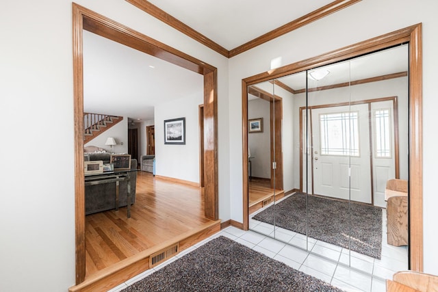 tiled entrance foyer featuring ornamental molding