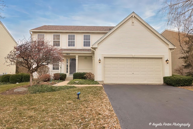 view of property featuring a front yard and a garage