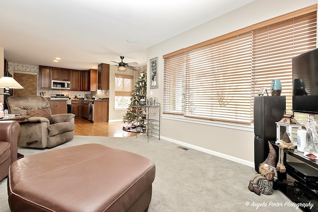 carpeted living room with ceiling fan