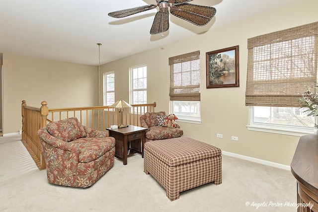 sitting room featuring ceiling fan, light colored carpet, and a wealth of natural light