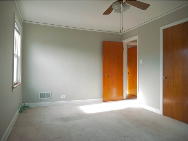 unfurnished room featuring ceiling fan, plenty of natural light, and light colored carpet