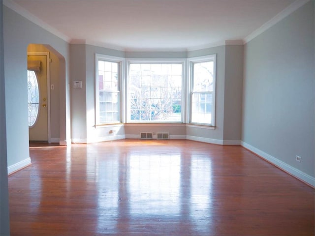 spare room with a wealth of natural light, light hardwood / wood-style flooring, and ornamental molding