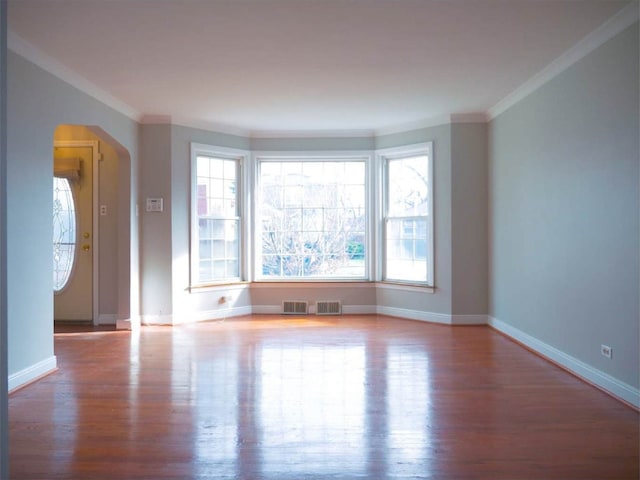 spare room featuring ornamental molding and light wood-type flooring