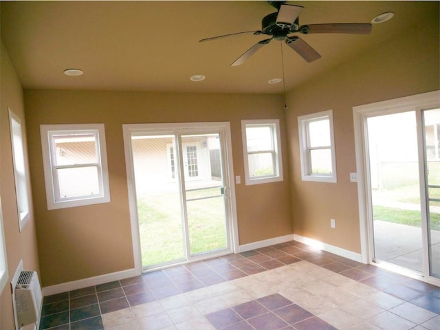 unfurnished sunroom with an AC wall unit and ceiling fan