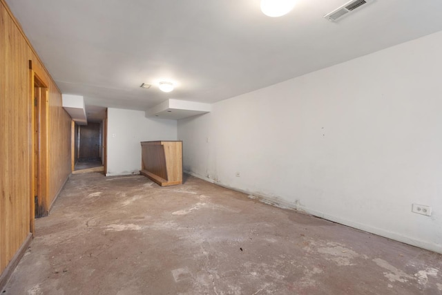 basement featuring wood walls