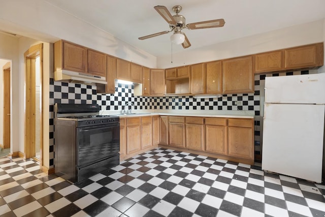 kitchen featuring decorative backsplash, gas stove, ceiling fan, sink, and white refrigerator