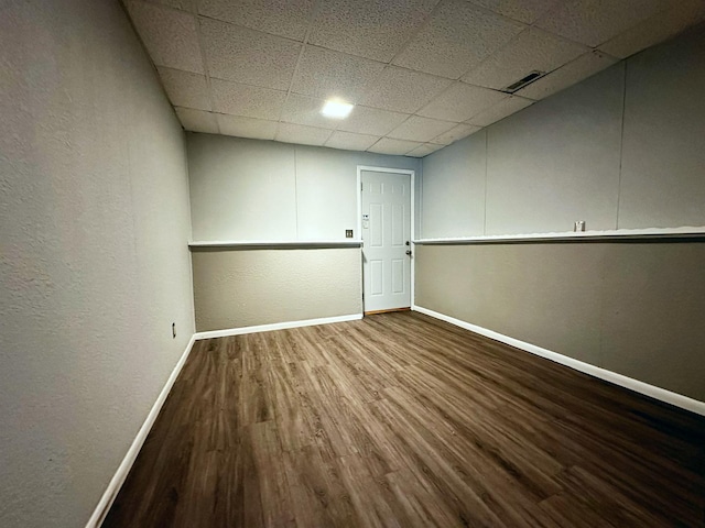 empty room featuring a paneled ceiling and hardwood / wood-style floors