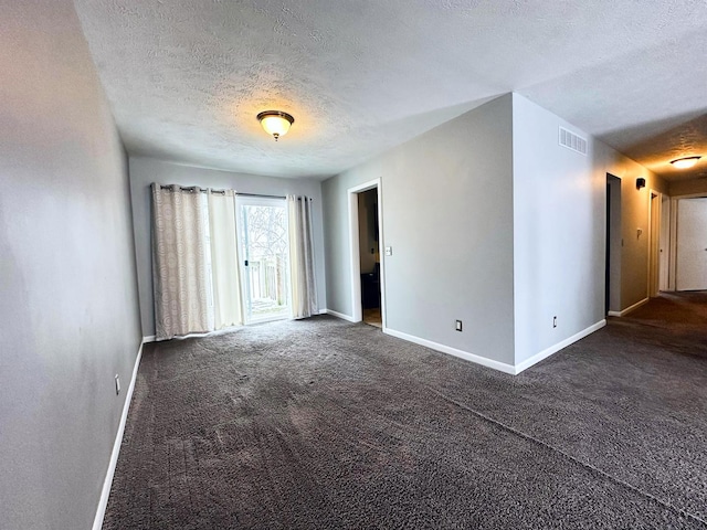 carpeted spare room with a textured ceiling