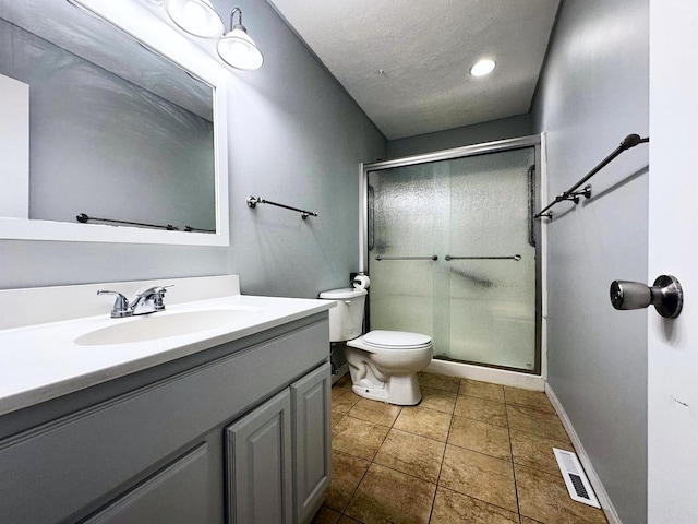 bathroom featuring walk in shower, tile patterned flooring, a textured ceiling, toilet, and vanity