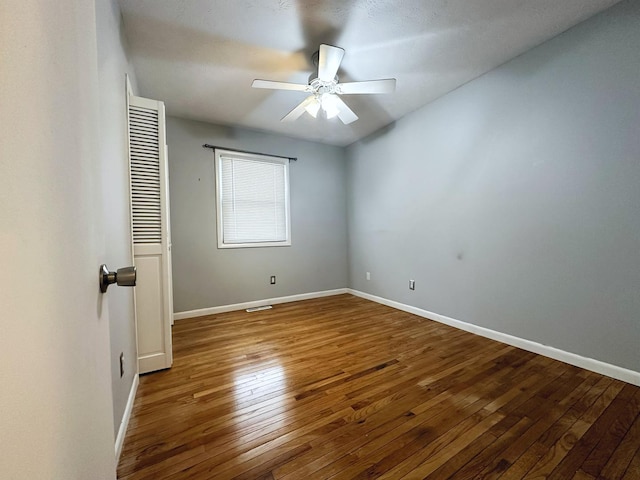 empty room with hardwood / wood-style floors and ceiling fan