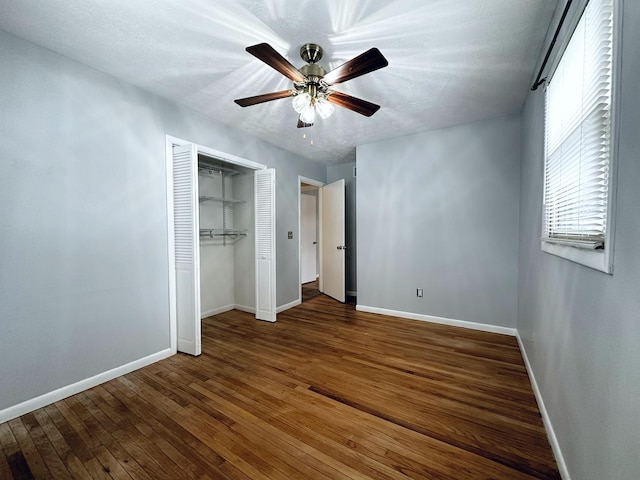 unfurnished bedroom featuring ceiling fan, dark hardwood / wood-style floors, and a closet