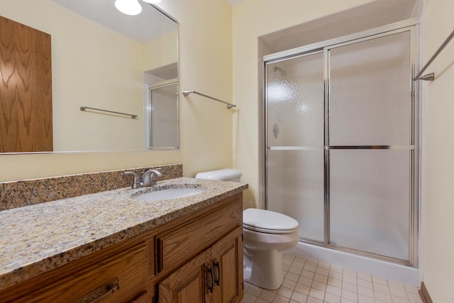 bathroom featuring tile patterned floors, vanity, toilet, and walk in shower