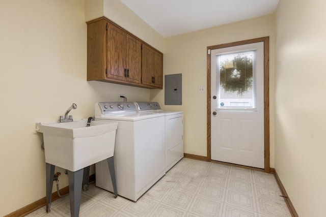 clothes washing area with washer and dryer, cabinets, and electric panel