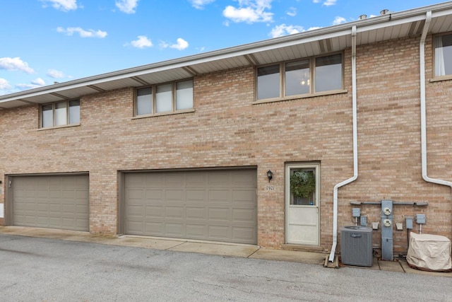 exterior space with a garage and cooling unit