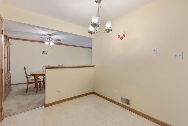 unfurnished dining area with ceiling fan with notable chandelier and ornamental molding