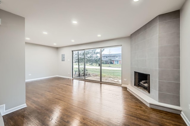 unfurnished living room with a tile fireplace and dark hardwood / wood-style flooring