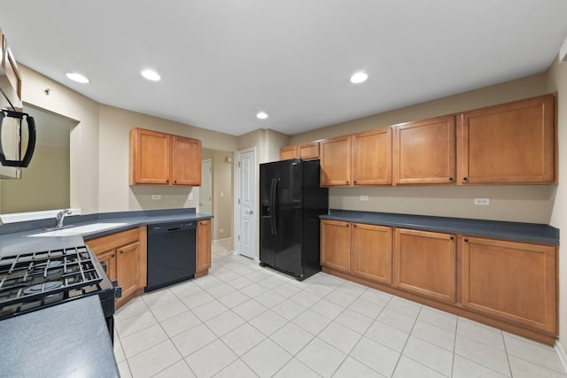 kitchen featuring sink, light tile patterned floors, and black appliances