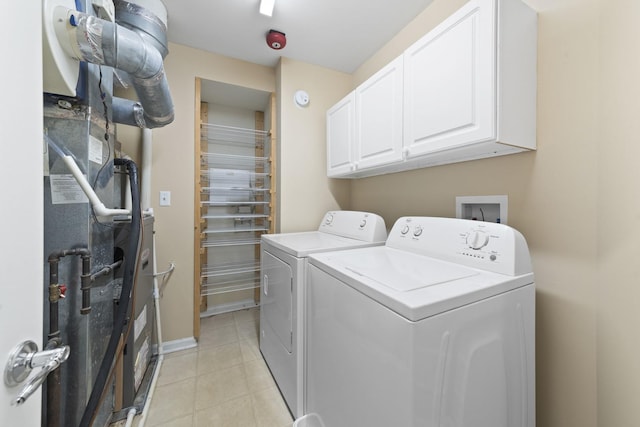 washroom featuring washing machine and clothes dryer, heating unit, and cabinets