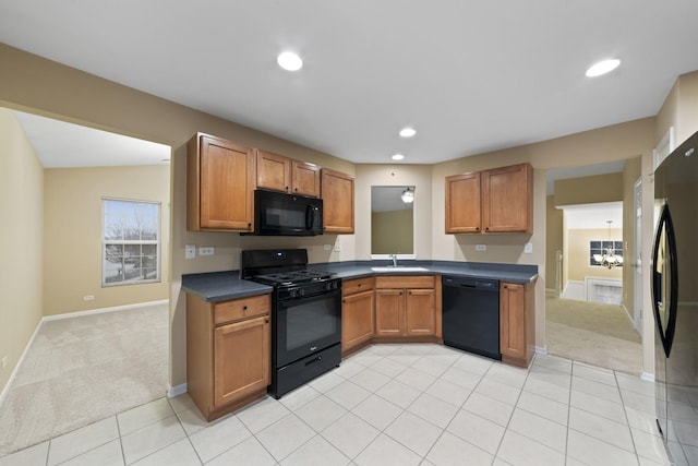 kitchen featuring sink, light colored carpet, a notable chandelier, and black appliances