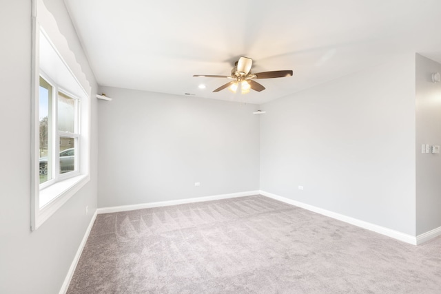 carpeted spare room featuring ceiling fan