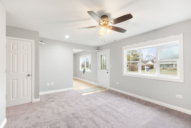 carpeted spare room featuring ceiling fan