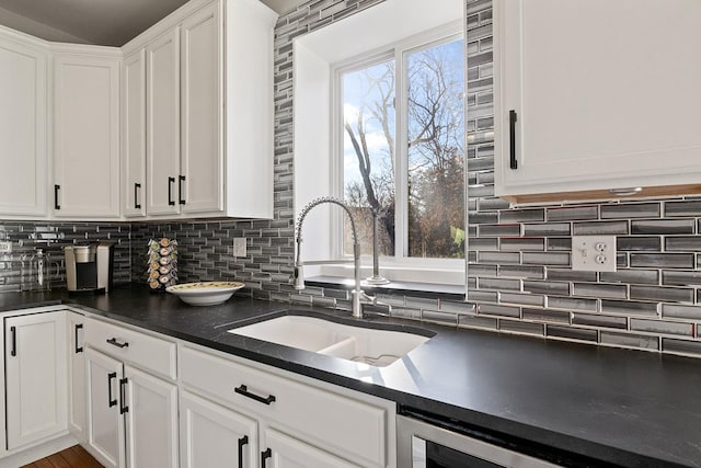 kitchen featuring sink, white cabinets, tasteful backsplash, and a wealth of natural light