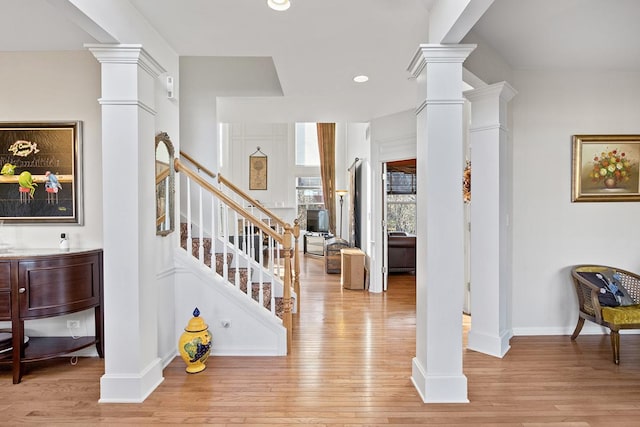 foyer entrance with decorative columns and light wood-type flooring