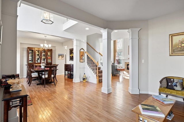 interior space featuring a brick fireplace, a notable chandelier, and light wood-type flooring