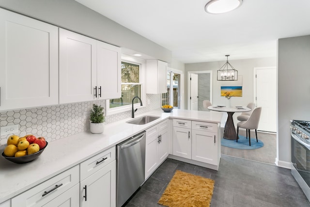 kitchen with sink, kitchen peninsula, appliances with stainless steel finishes, decorative light fixtures, and white cabinetry