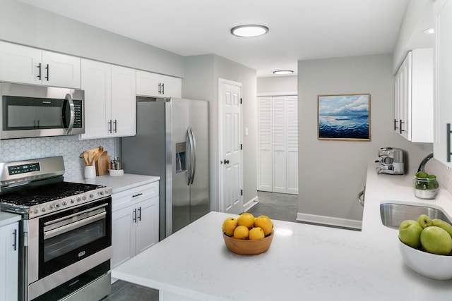 kitchen with backsplash, white cabinetry, and appliances with stainless steel finishes