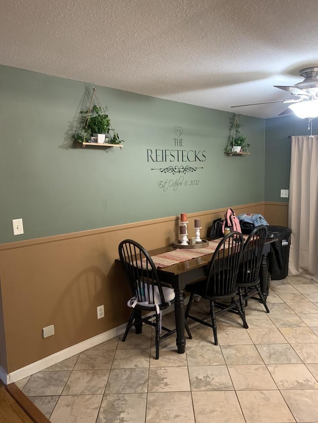 dining space featuring ceiling fan and a textured ceiling