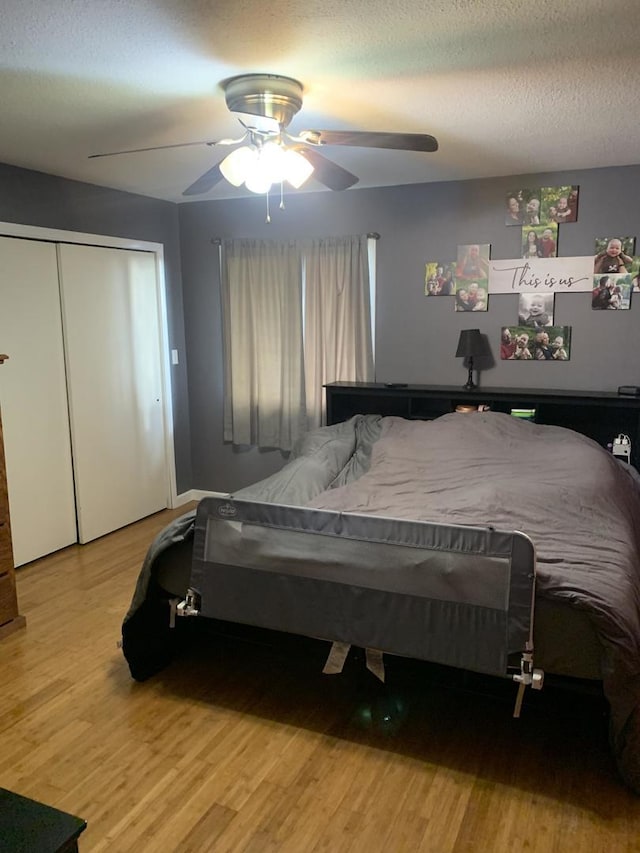 bedroom with wood-type flooring, a textured ceiling, a closet, and ceiling fan