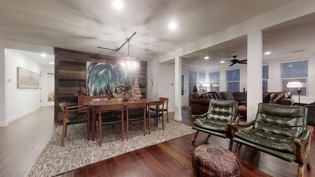 dining area with hardwood / wood-style floors and ceiling fan with notable chandelier