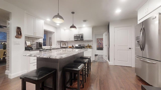 kitchen featuring decorative backsplash, white cabinets, and stainless steel appliances