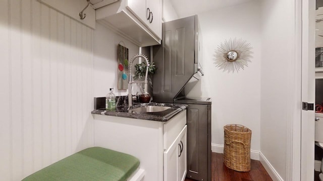 interior space with hardwood / wood-style floors, vanity, and stacked washer and clothes dryer