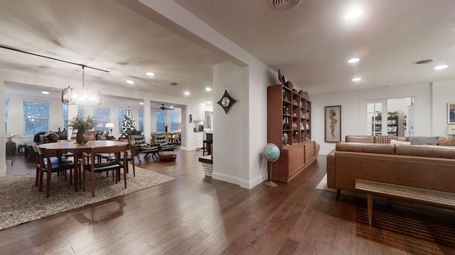 living room featuring ceiling fan with notable chandelier and dark hardwood / wood-style floors