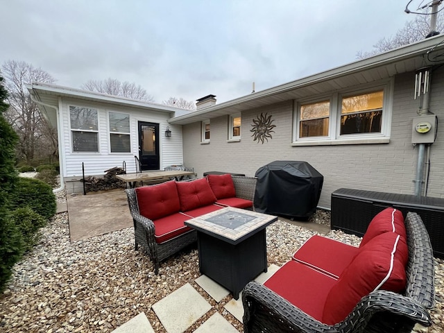 view of patio with a grill and an outdoor living space with a fire pit