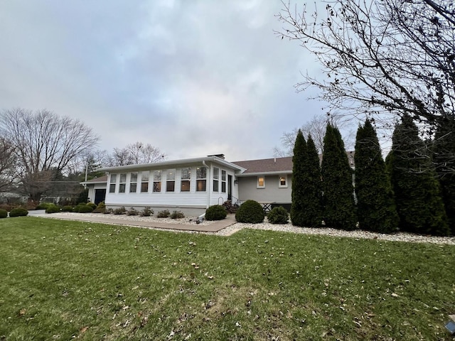 view of front of house featuring a front yard and a sunroom