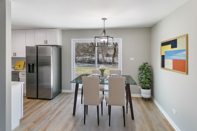 dining space with a chandelier and light hardwood / wood-style flooring