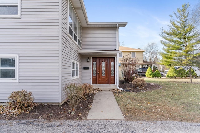 view of exterior entry with a lawn