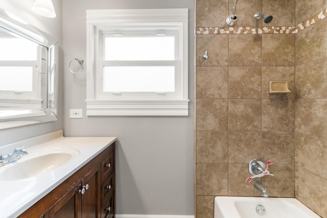 bathroom with tiled shower / bath combo and vanity