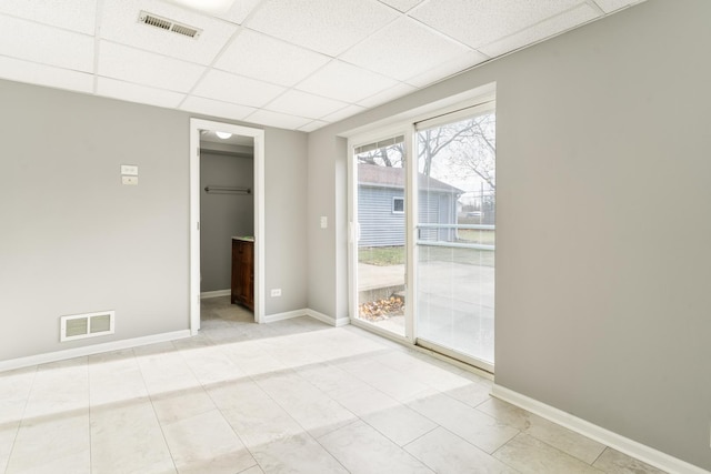 unfurnished room featuring light tile patterned floors and a drop ceiling