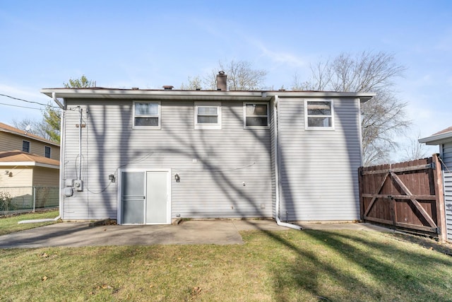 back of property with a patio area and a lawn