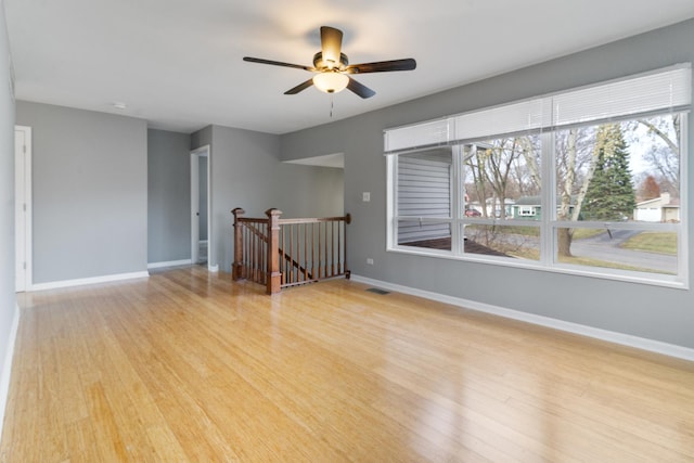 spare room with light wood-type flooring and ceiling fan