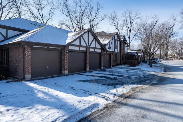 snow covered property featuring a garage